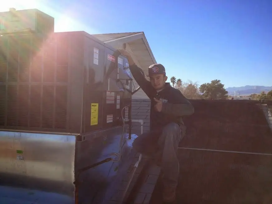 HVAC technician performing Air Duct Repair on a rooftop unit in Fulton